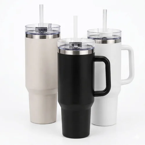 Three large stainless steel tumblers in beige, black, and white colors, each with a straw and handle.